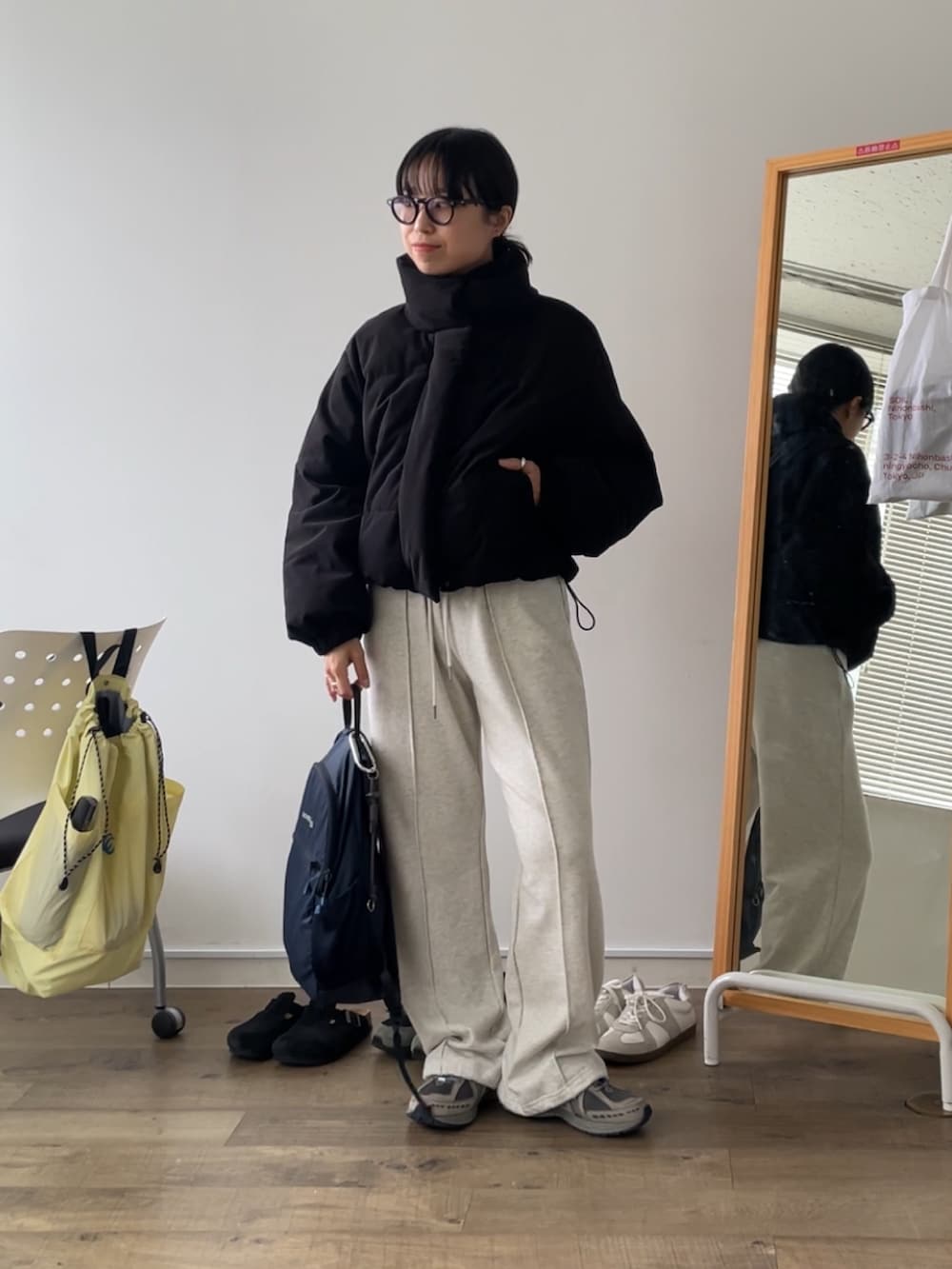 ブラック系のブルゾン、ホワイト系のスウェットパンツを着用したレディースの秋コーディネートの2枚目の写真