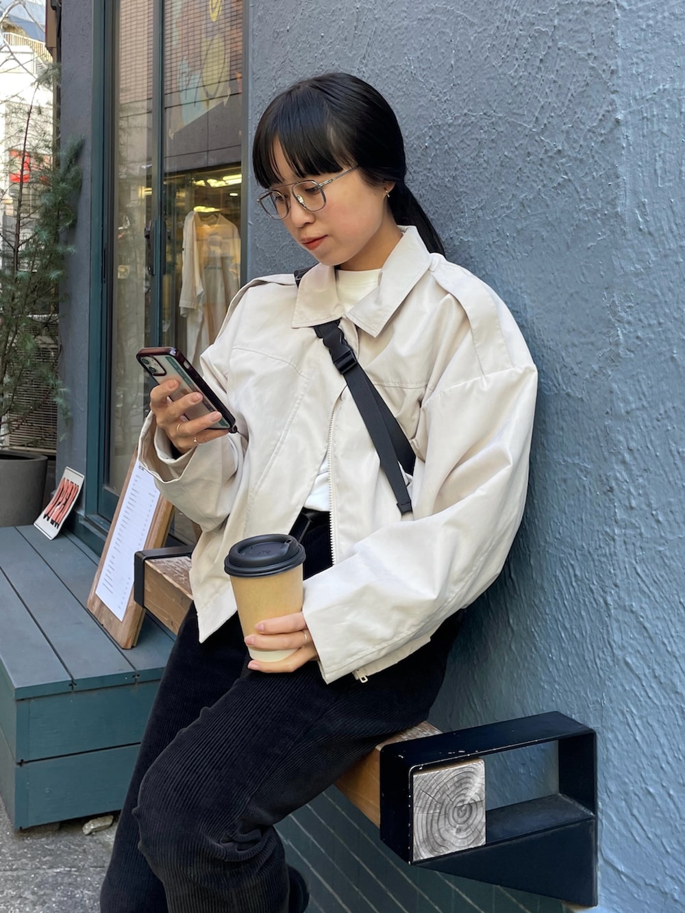 ホワイト系のブルゾン、ブラック系のボディバッグ/ウエストポーチを着用したレディースの冬コーディネートの2枚目の写真