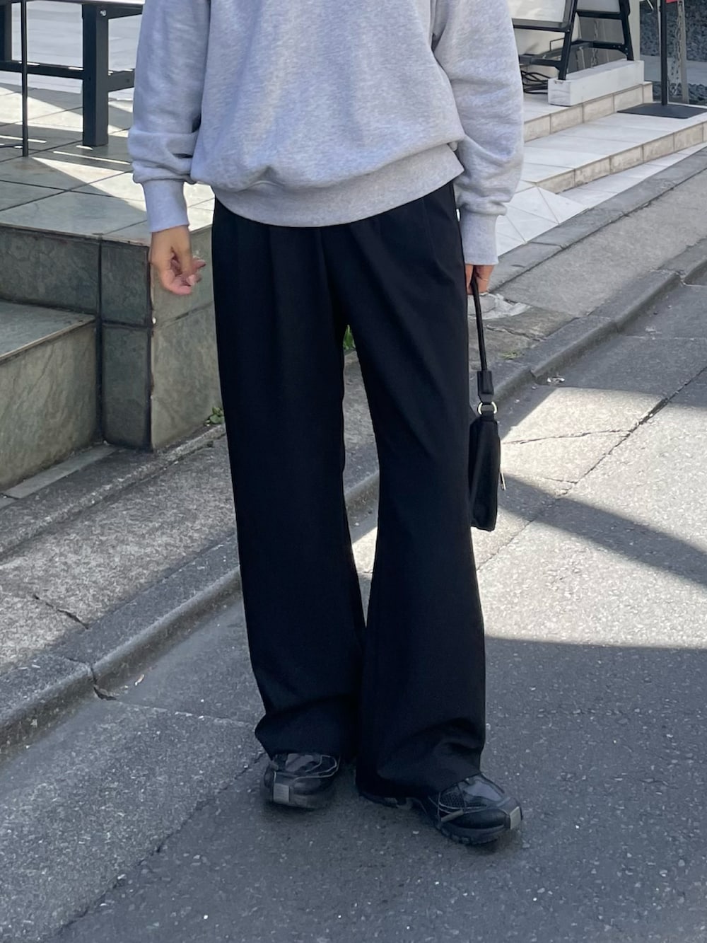 グレー系のその他パンツ、ブラック系のハンドバッグ、グレー系のスウェットを着用したレディースの秋コーディネートの3枚目の写真