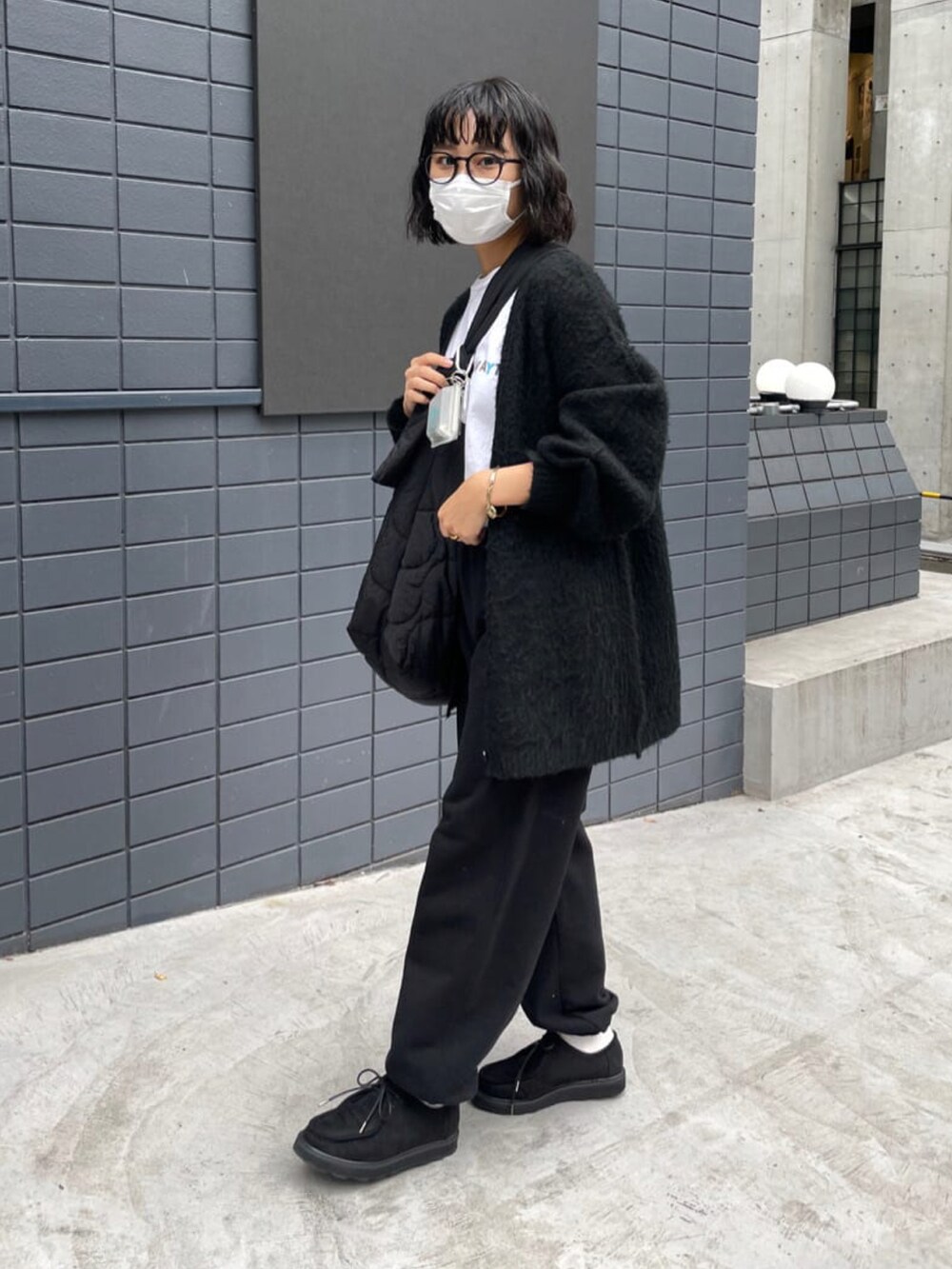 ブラック系のモカシン/デッキシューズ、グレー系のスウェットパンツ、ブラック系のショルダーバッグを着用したレディースの秋コーディネートの2枚目の写真