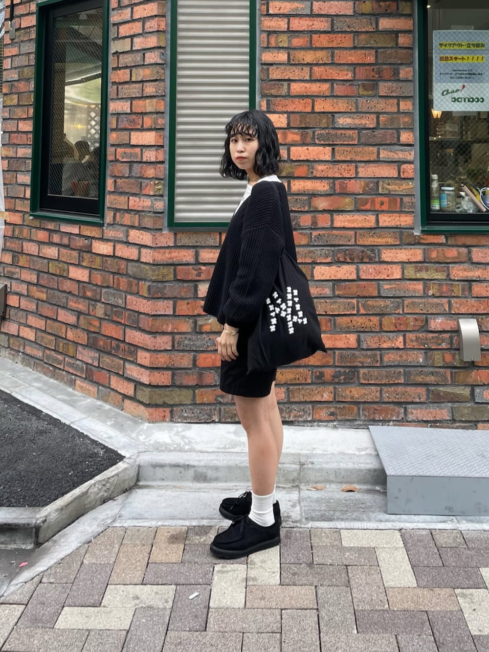 ブラック系のニット/セーター、ブラック系のモカシン/デッキシューズ、ブラック系のパンツを着用したレディースの冬コーディネートの3枚目の写真