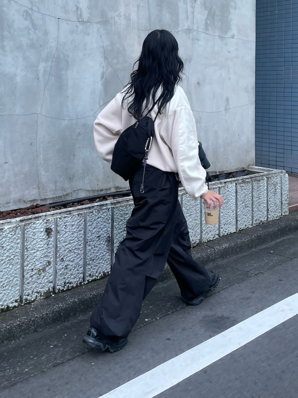 ホワイト系のブルゾン、ブラック系のバックパック/リュック、ブラック系のその他パンツを着用したレディースの秋コーディネートの2枚目の写真