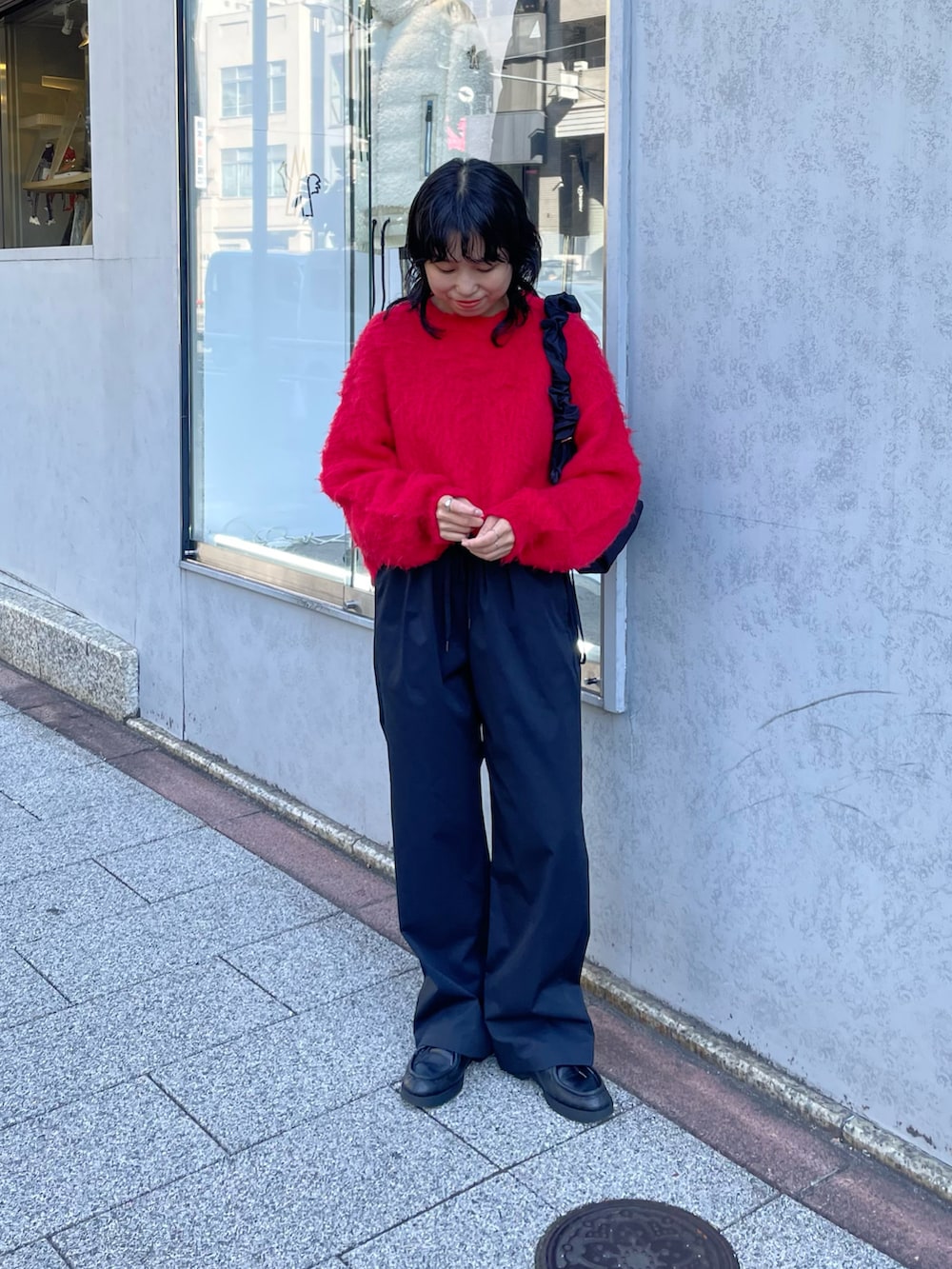 ブルー系のニット/セーター、ブラック系のその他パンツ、ブラック系のショルダーバッグを着用したレディースの秋コーディネートの2枚目の写真