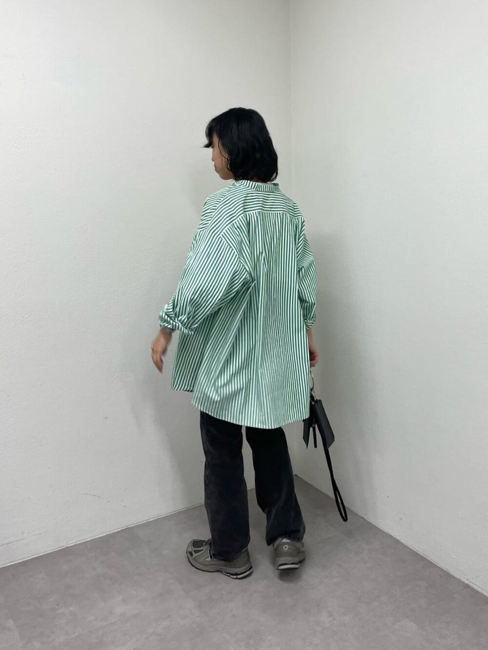 ブラック系のデニムパンツ、ホワイト系のTシャツ/カットソー、グリーン系のシャツ/ブラウスを着用したレディースの冬コーディネートの2枚目の写真