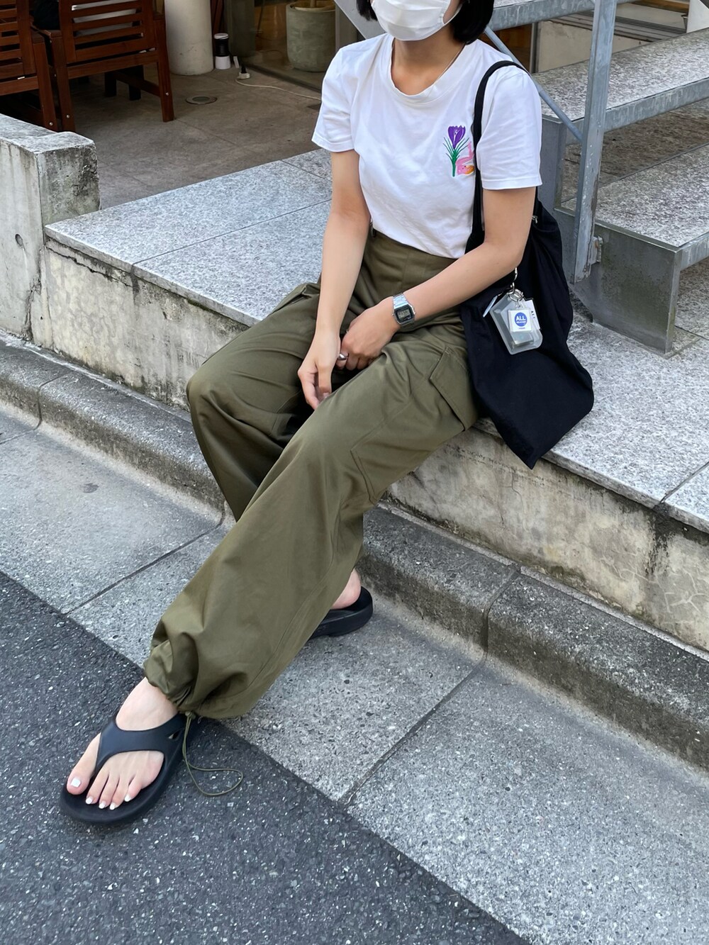 ブラック系のサンダルを着用したレディースの夏コーディネートの2枚目の写真