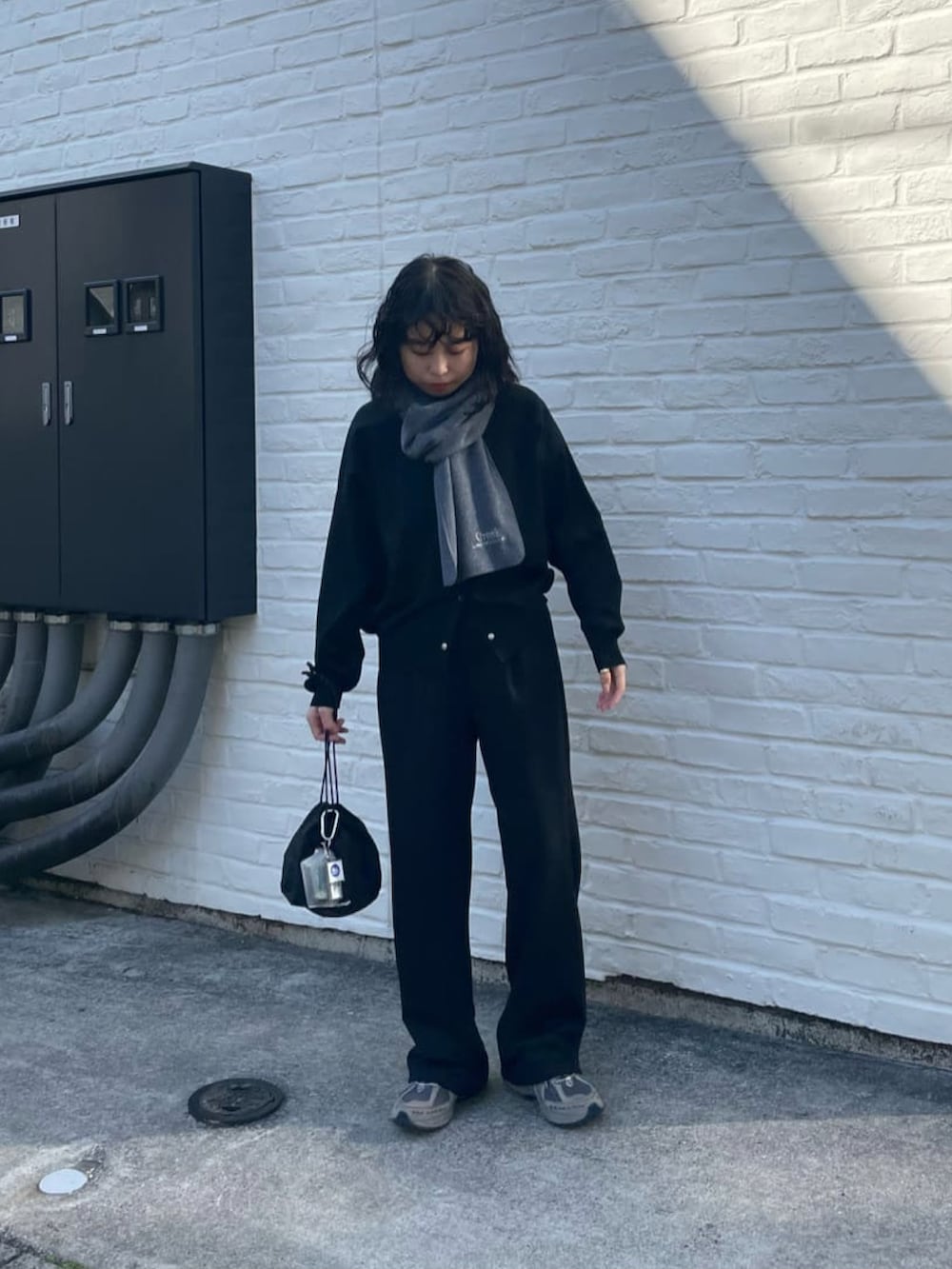 ブラック系のハンドバッグ、ブラック系のその他パンツ、ブラック系のカーディガン/ボレロを着用したレディースの冬コーディネートの2枚目の写真