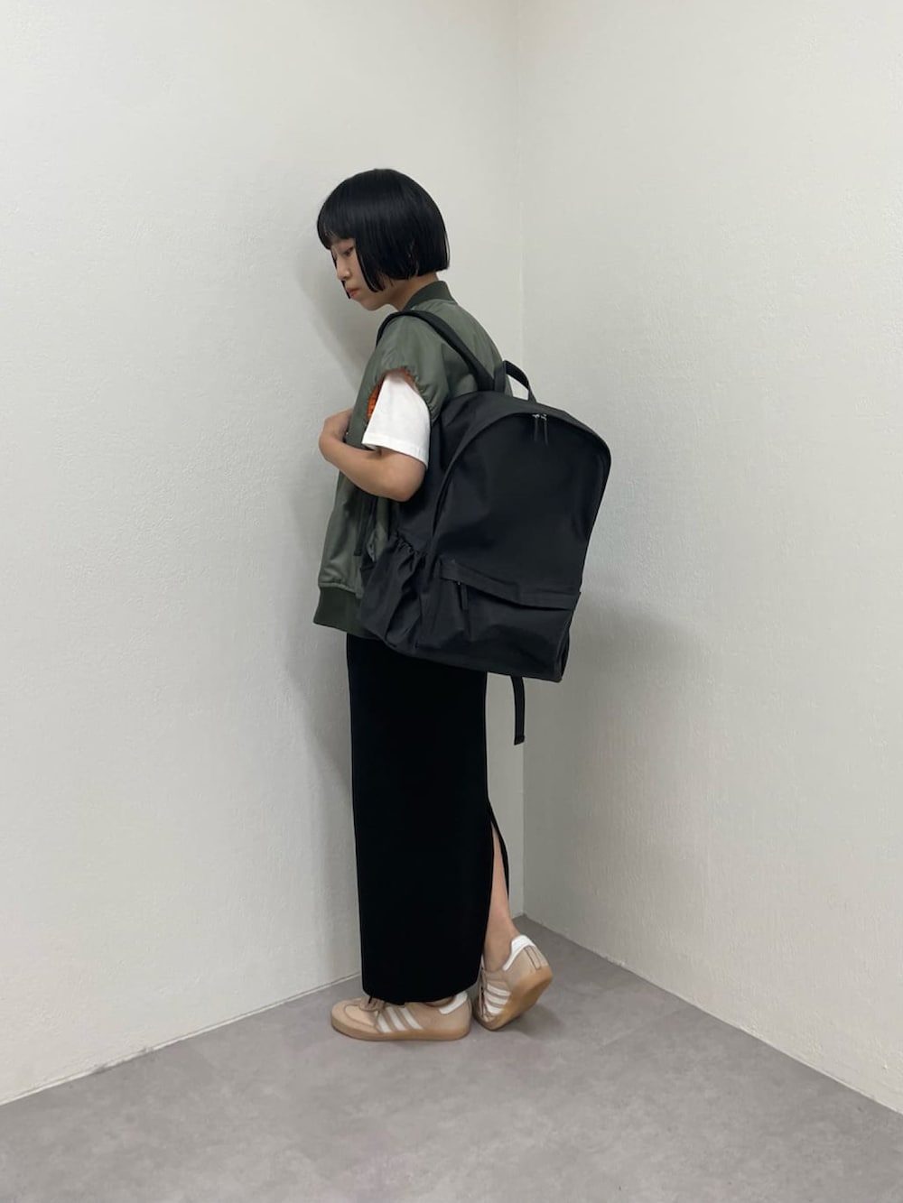ブラック系のスカート、ブラック系のベスト、ホワイト系のTシャツ/カットソーを着用したレディースの夏コーディネートの3枚目の写真