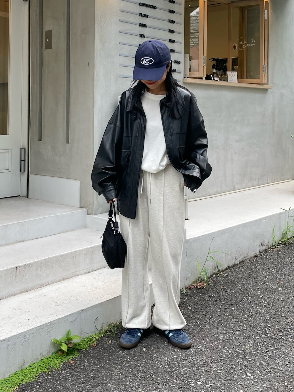 ホワイト系のスウェットパンツ、ブルー系のTシャツ/カットソー、ブラック系のブルゾンを着用したレディースの夏コーディネートの2枚目の写真