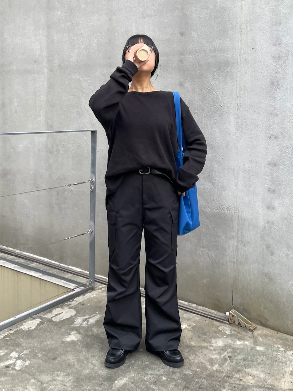 ブラック系のカーゴパンツ、ブルー系のショルダーバッグを着用したレディースの冬コーディネートの2枚目の写真