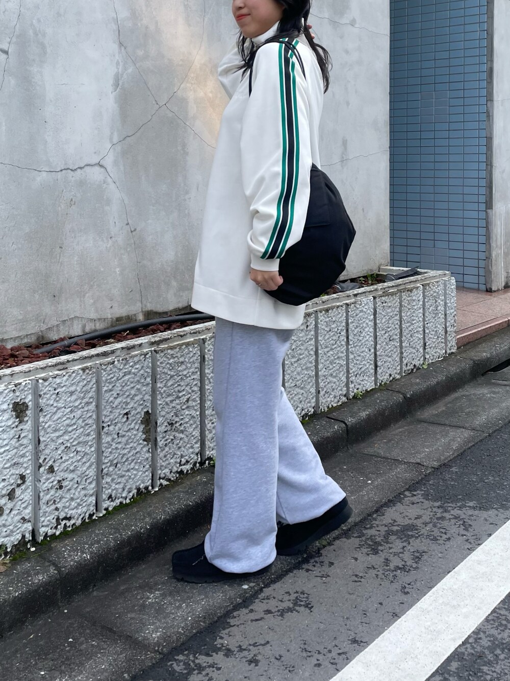 グレー系のスウェットパンツ、ホワイト系のジャージを着用したレディースの春コーディネートの3枚目の写真