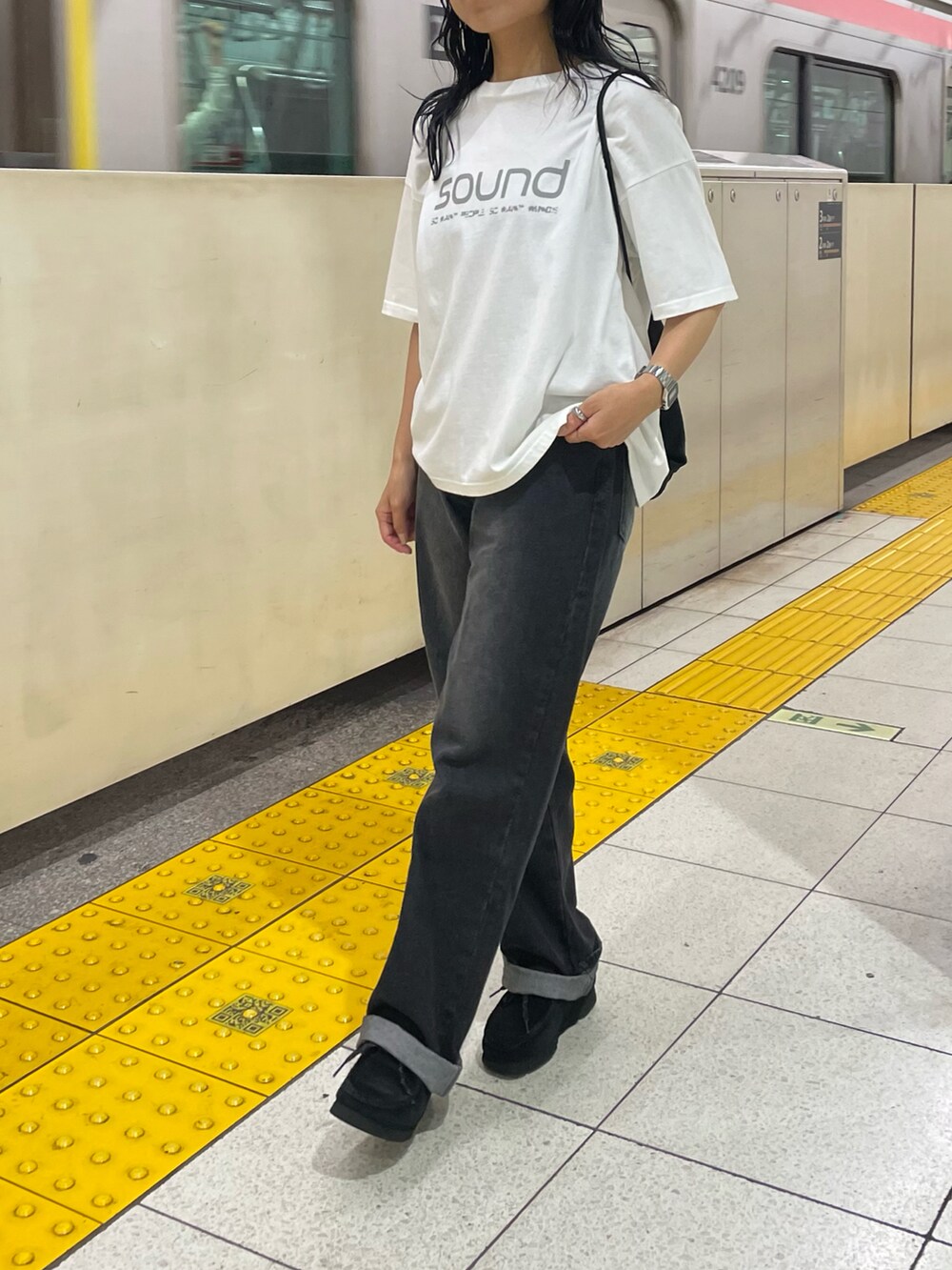 ブラック系のデニムパンツ、ブラック系のバックパック/リュック、ブルー系のTシャツ/カットソーを着用したレディースの夏コーディネートの2枚目の写真