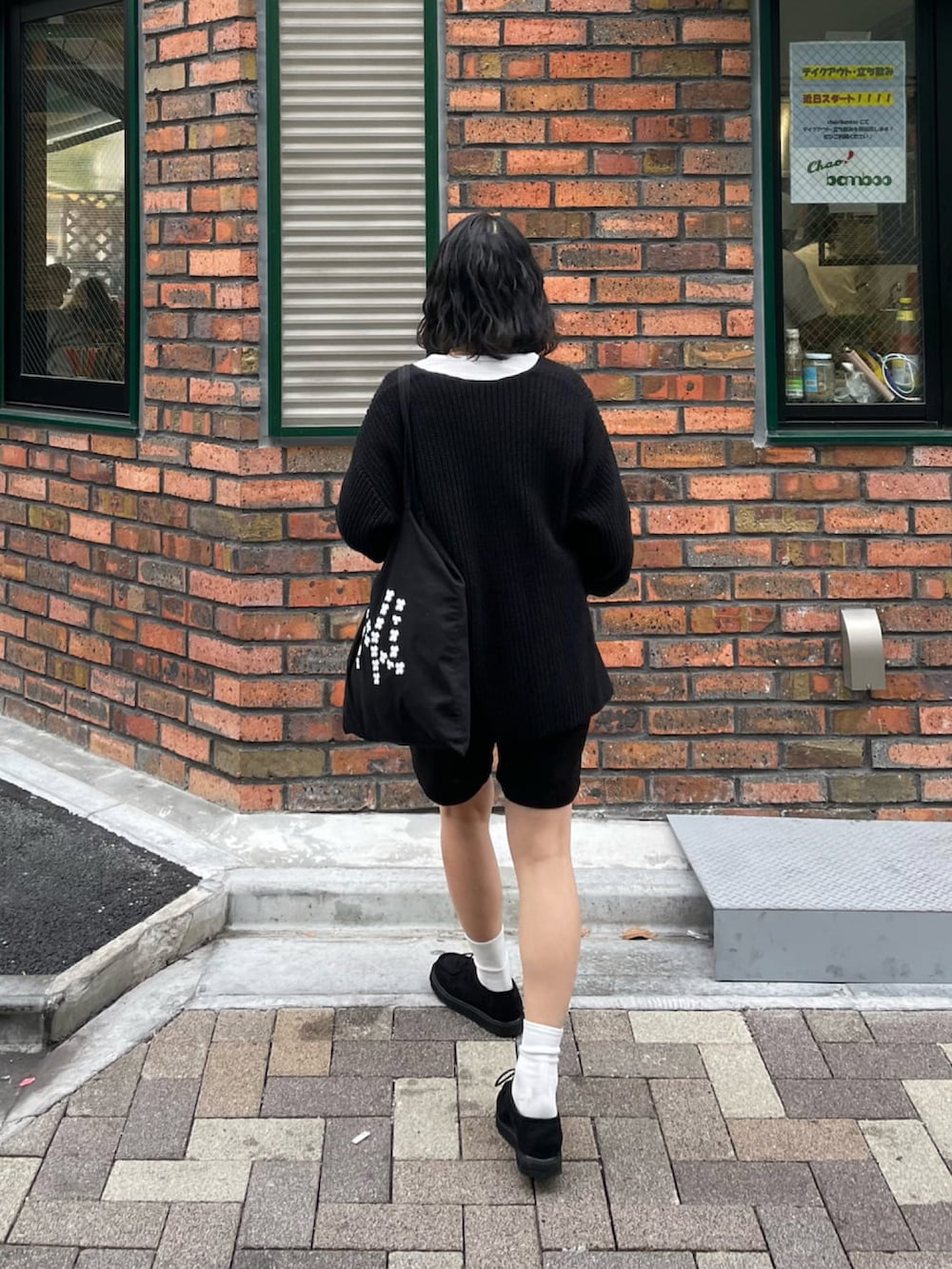 ブラック系のニット/セーター、ブラック系のモカシン/デッキシューズ、ブラック系のパンツを着用したレディースの冬コーディネートの2枚目の写真