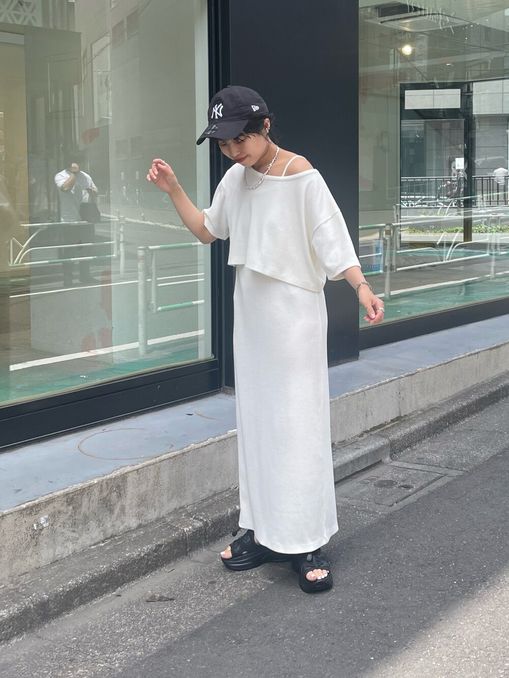 ホワイト系のサンダル、グリーン系のワンピースを着用したレディースの春コーディネートの2枚目の写真