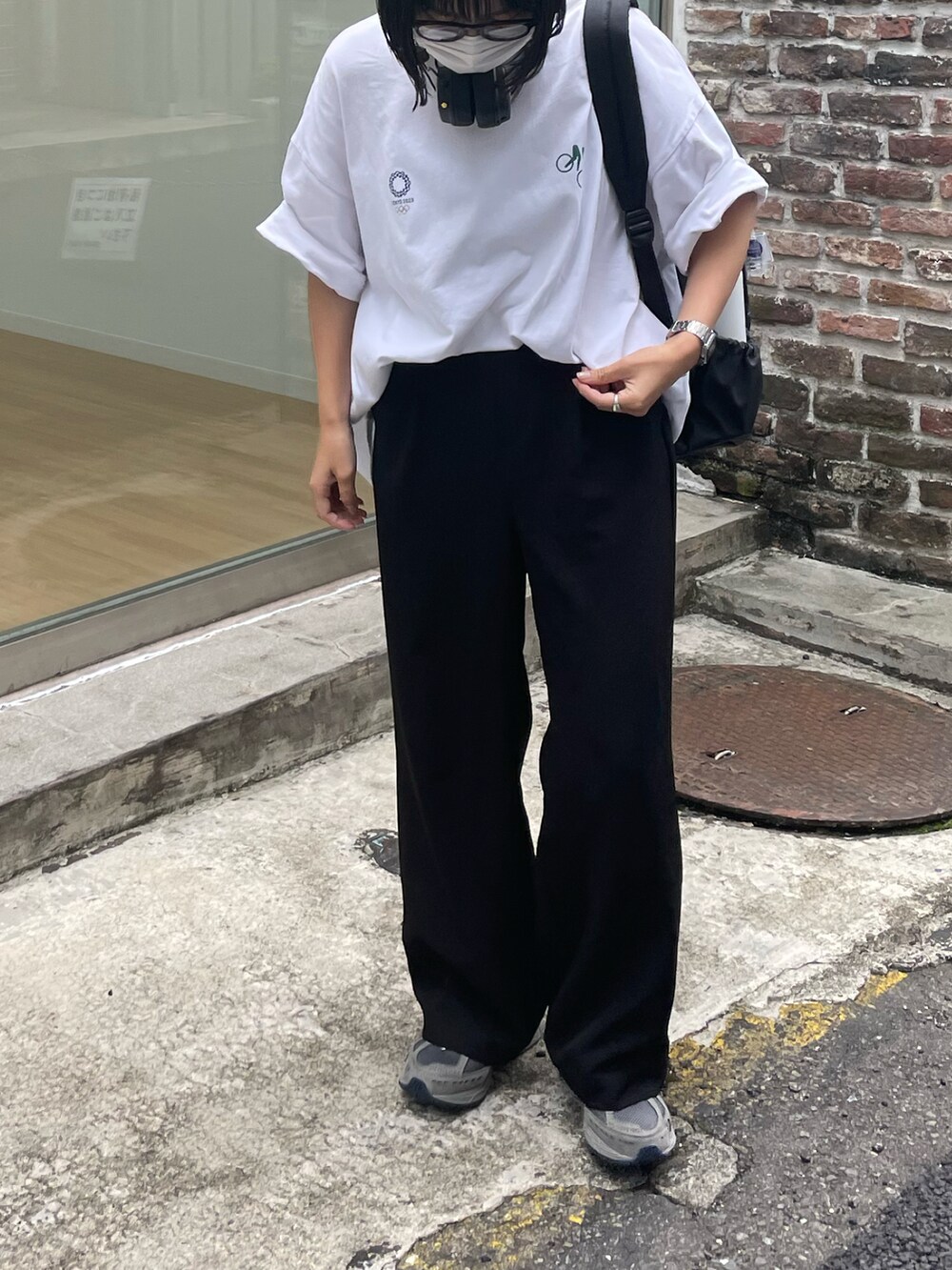 ベージュ系のスラックス、ブラック系のバックパック/リュックを着用したレディースの夏コーディネートの3枚目の写真