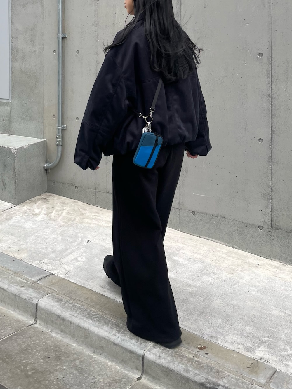 ブラック系のブルゾン、ブラック系のスウェットパンツ、ブラック系のショルダーバッグを着用したレディースの秋コーディネートの2枚目の写真