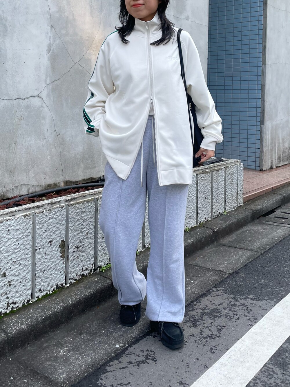 グレー系のスウェットパンツ、ホワイト系のジャージを着用したレディースの春コーディネートの2枚目の写真