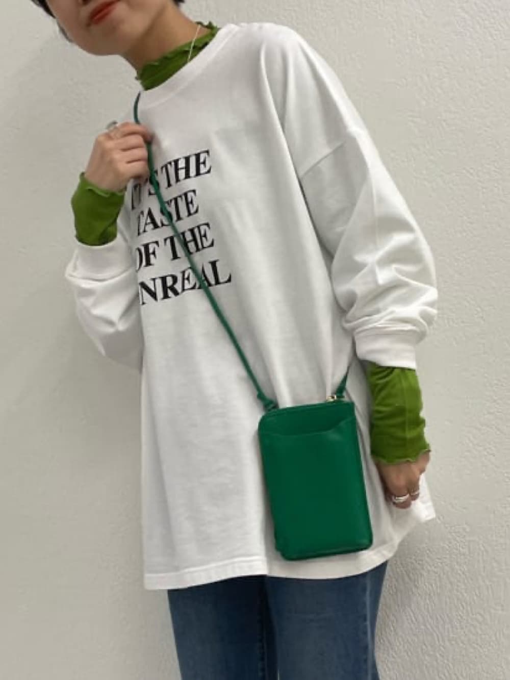 ホワイト系のTシャツ/カットソー、ブラック系のショルダーバッグ、ホワイト系のスリッポンを着用したレディースの春コーディネートの2枚目の写真