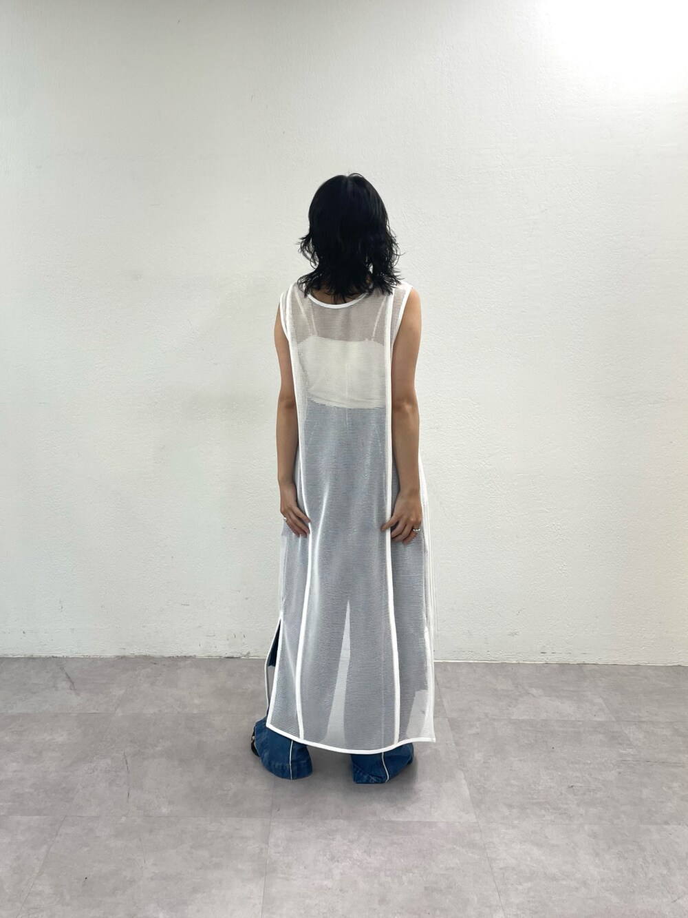 ブラック系のワンピース、ブラック系のデニムパンツ、ブラック系のサンダルを着用したレディースの夏コーディネートの2枚目の写真