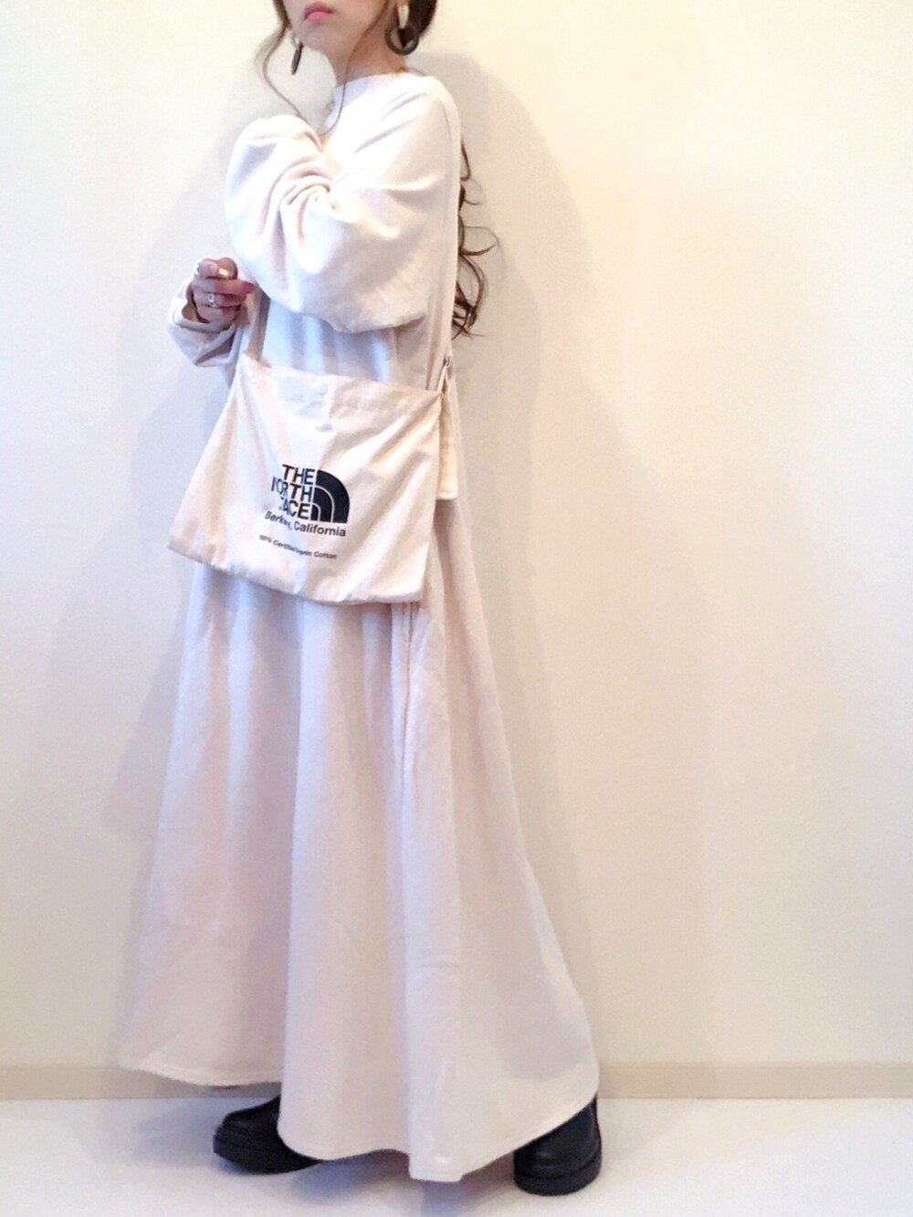 ホワイト系のショルダーバッグ、ブラック系のブーツ、ホワイト系のワンピースを着用したレディースの秋コーディネートの2枚目の写真