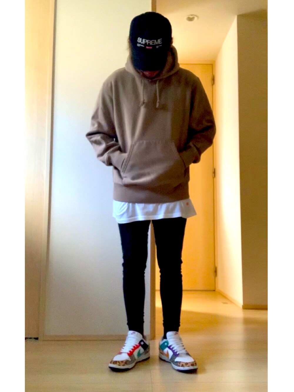 ブラック系のジャケット/アウター、その他のスニーカー、ブラック系のキャップを着用したメンズの冬コーディネートの2枚目の写真