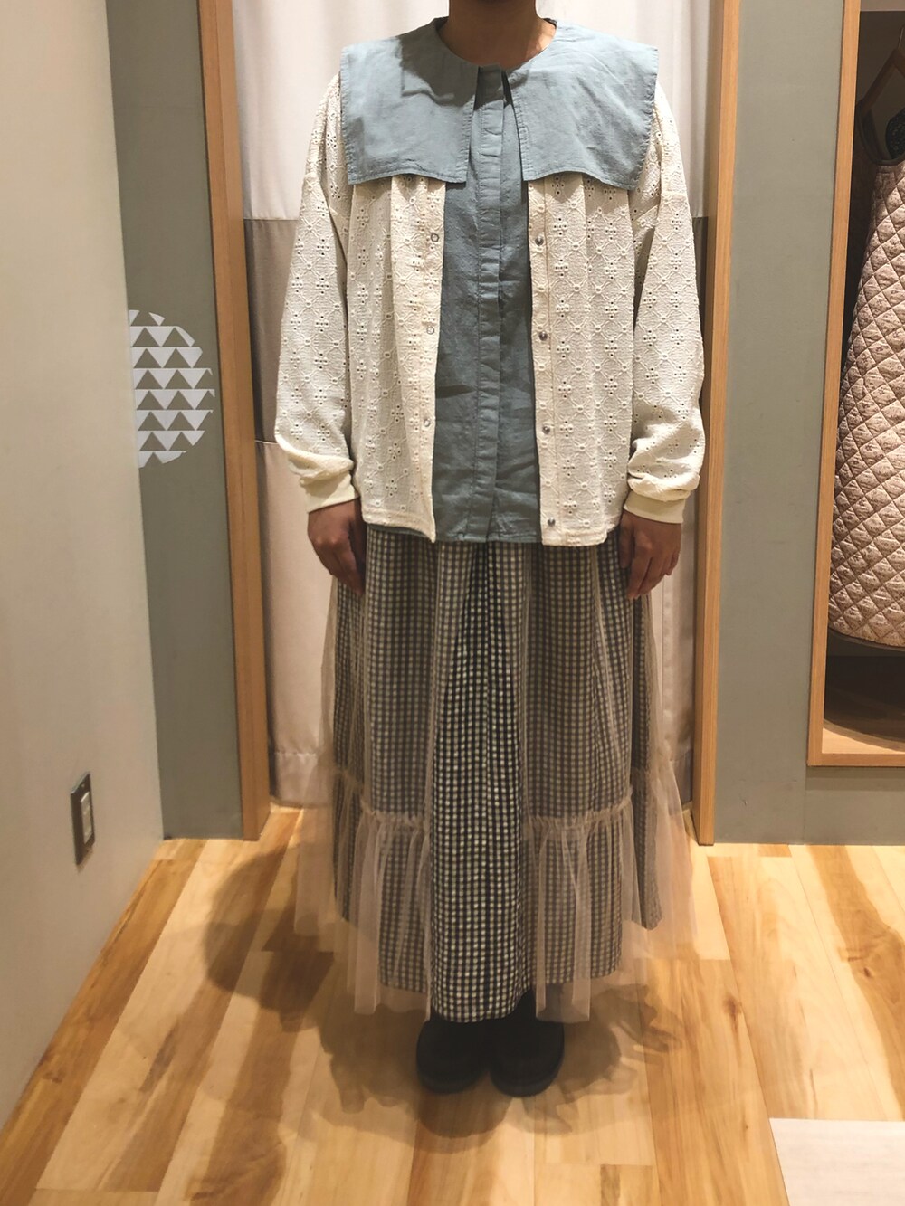 ブラウン系のショルダーバッグ、ブラウン系のサンダル、ホワイト系のスカートを着用したレディースの秋コーディネートの2枚目の写真