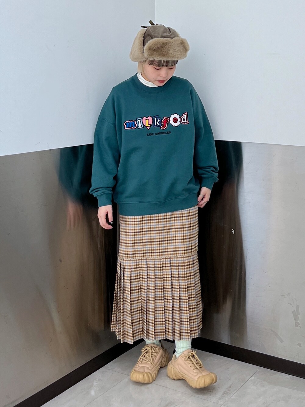 ベージュ系のスカート、グリーン系のスウェット、ブラウン系のボストンバッグを着用したレディースの冬コーディネートの3枚目の写真