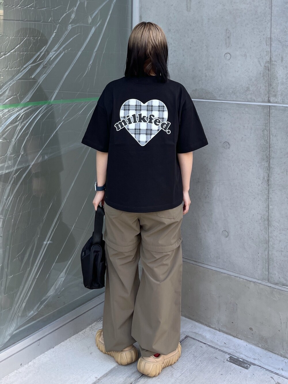 ブラック系のTシャツ/カットソー、ブラック系のハンドバッグ、グリーン系のその他パンツを着用したレディースの春コーディネートの2枚目の写真