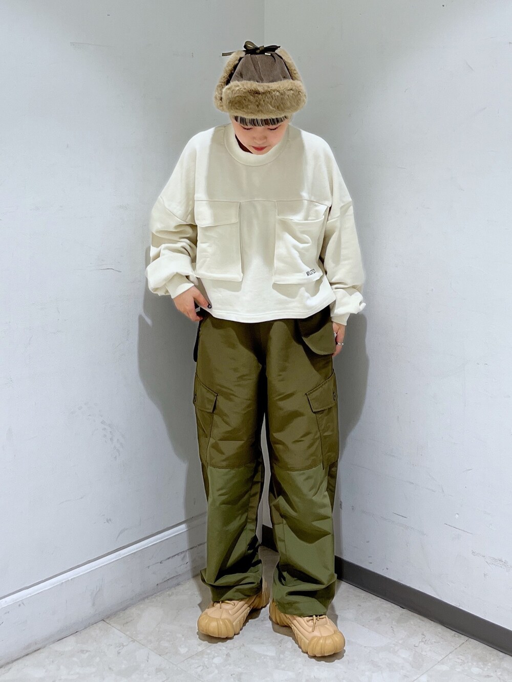 ホワイト系のスウェット、グリーン系のカーゴパンツ、ブラウン系のショルダーバッグを着用したレディースの秋コーディネートの3枚目の写真