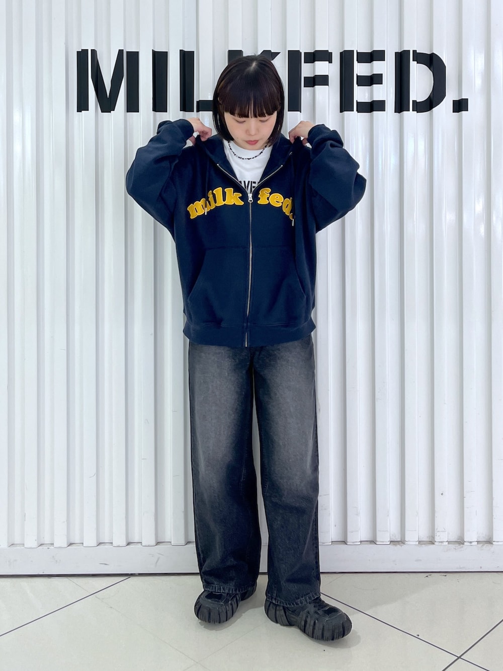 ブルー系のパーカー、ブラック系のデニムパンツ、ブラック系のお弁当箱を着用したレディースの秋コーディネートの3枚目の写真