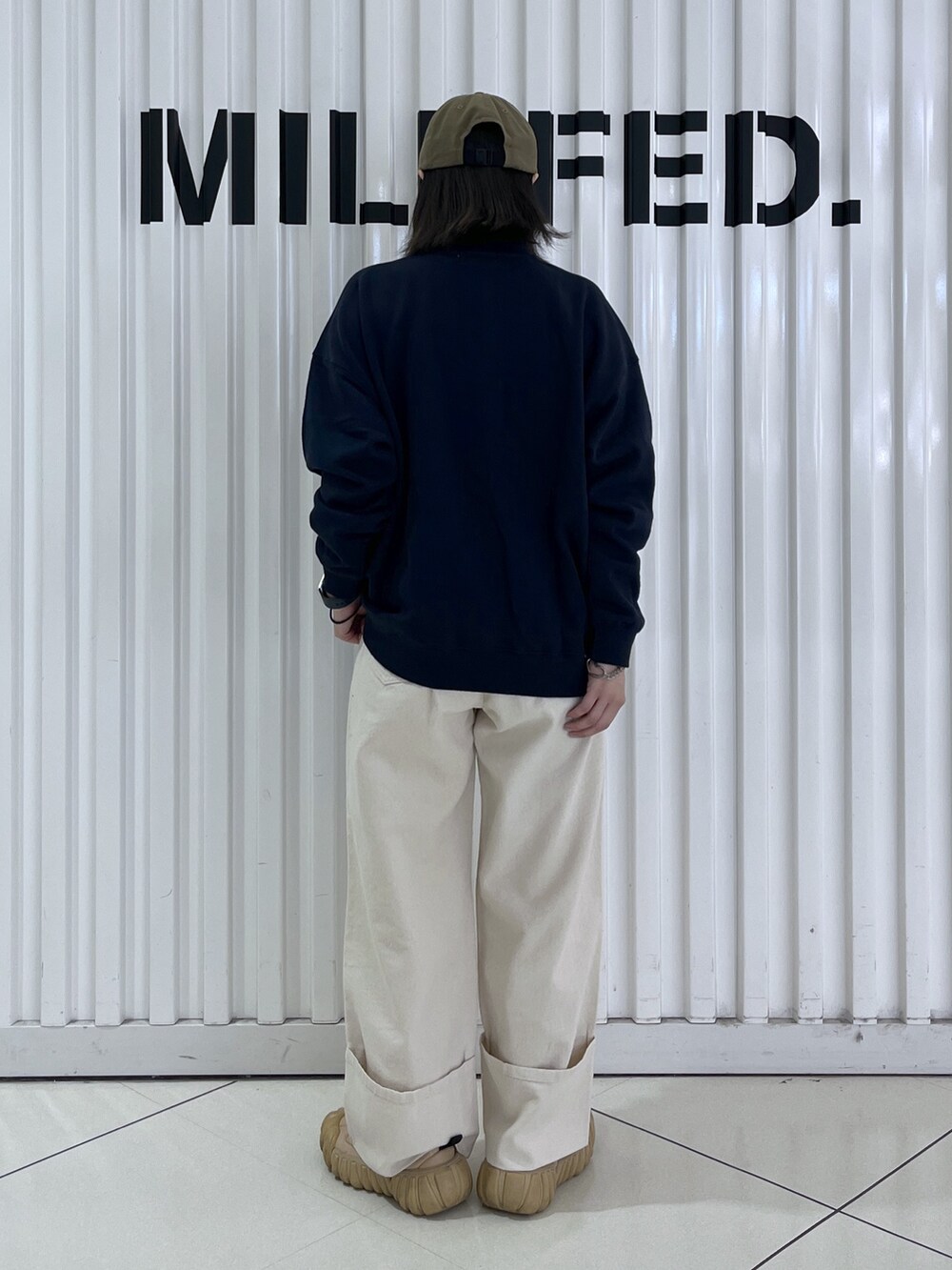 ブルー系のスウェット、グレー系のトートバッグ、ホワイト系のデニムパンツを着用したレディースの秋コーディネートの5枚目の写真