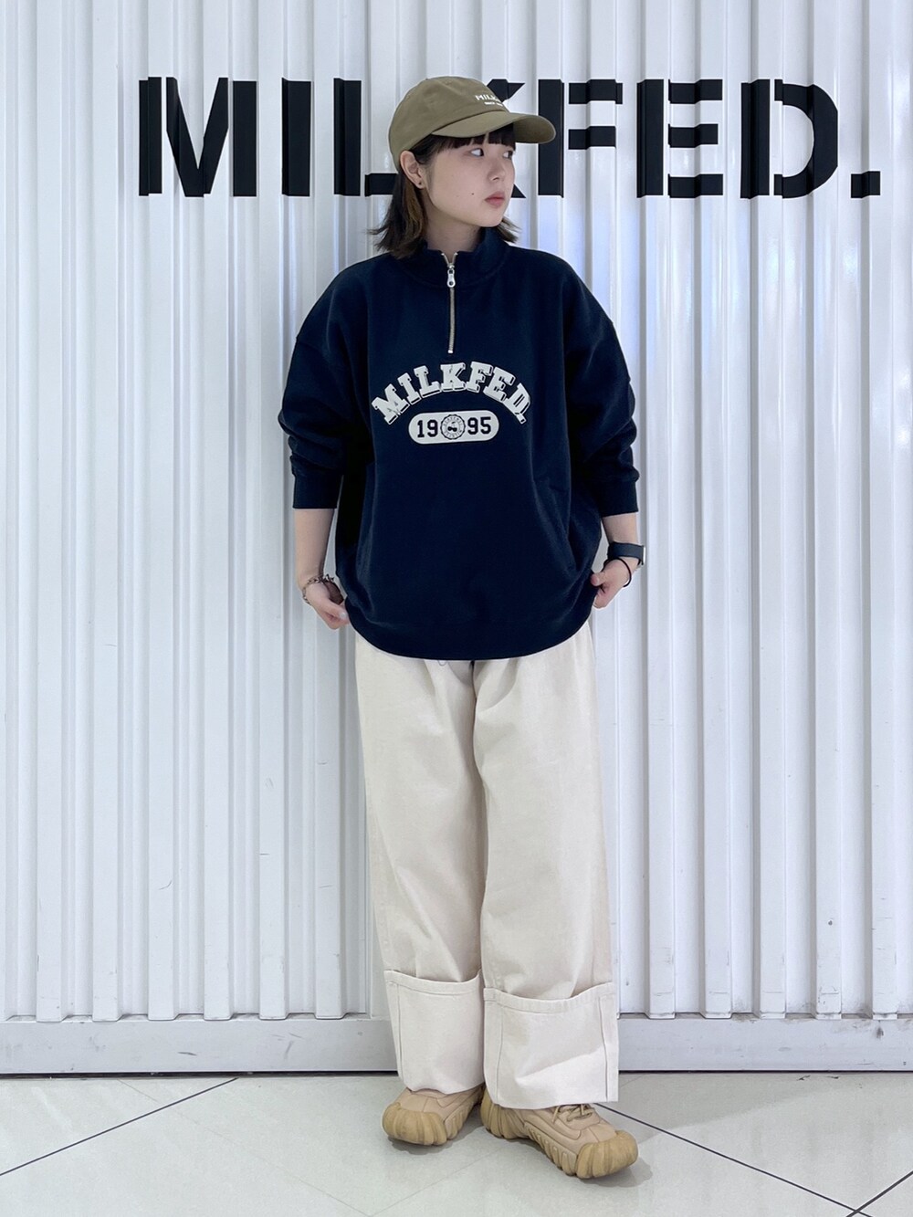 ブルー系のスウェット、グレー系のトートバッグ、ホワイト系のデニムパンツを着用したレディースの秋コーディネートの4枚目の写真