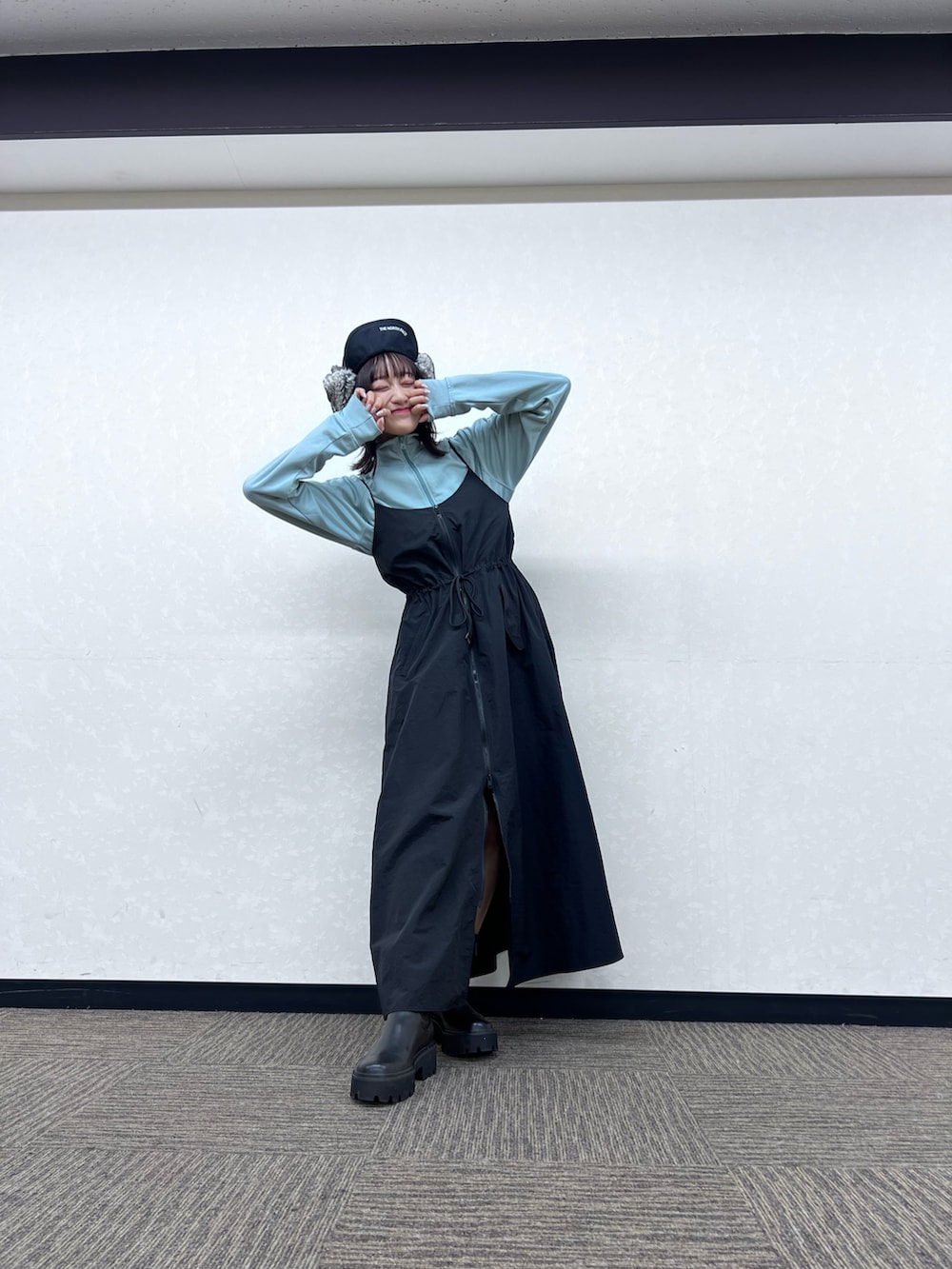 ブルー系のジャージ、ブラック系のワンピース、ブラック系のブーツを着用したレディースの秋コーディネートの4枚目の写真