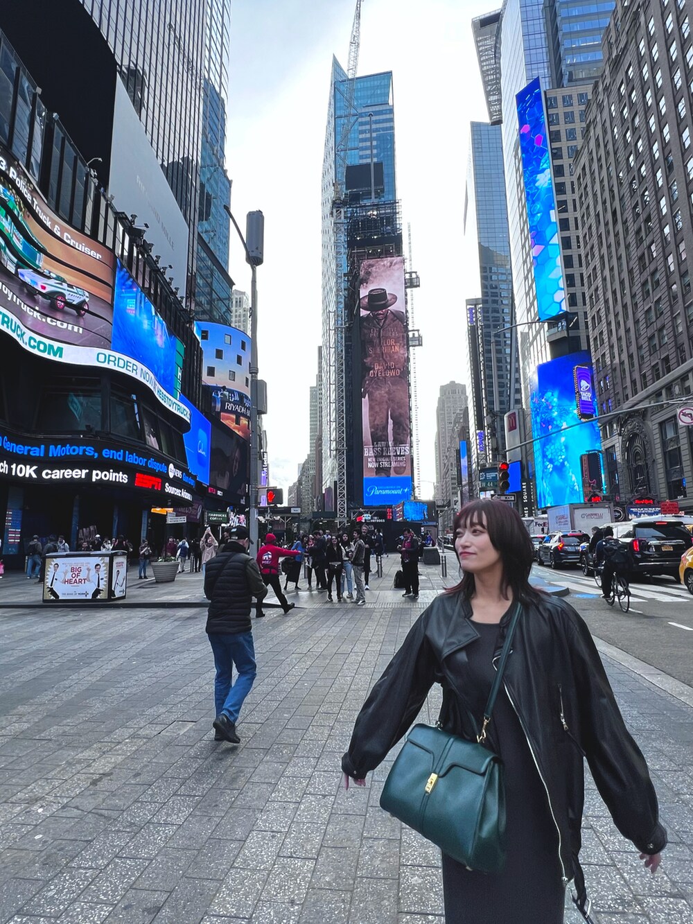 グレー系のワンピース、ブラック系のライダースジャケット、ブラック系のブーツを着用したレディースの秋コーディネートの4枚目の写真