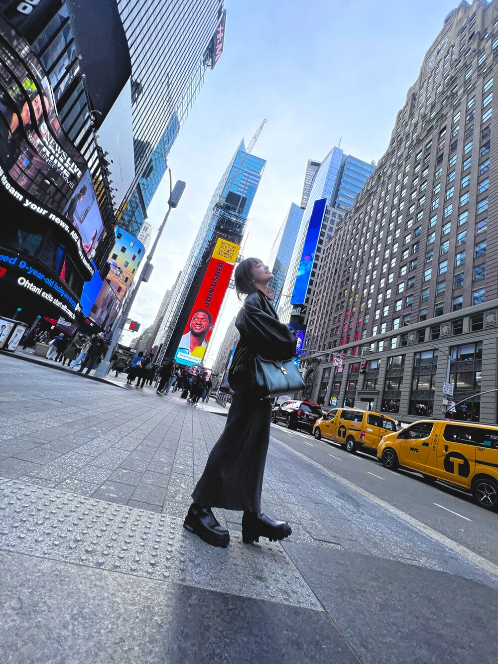 グレー系のワンピース、ブラック系のライダースジャケット、ブラック系のブーツを着用したレディースの秋コーディネートの3枚目の写真