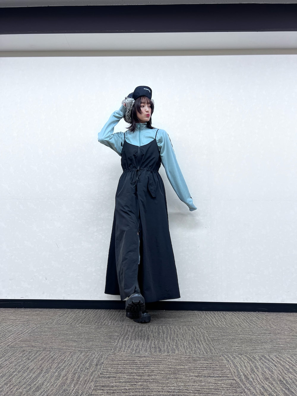 ブルー系のジャージ、ブラック系のワンピース、ブラック系のブーツを着用したレディースの秋コーディネートの2枚目の写真