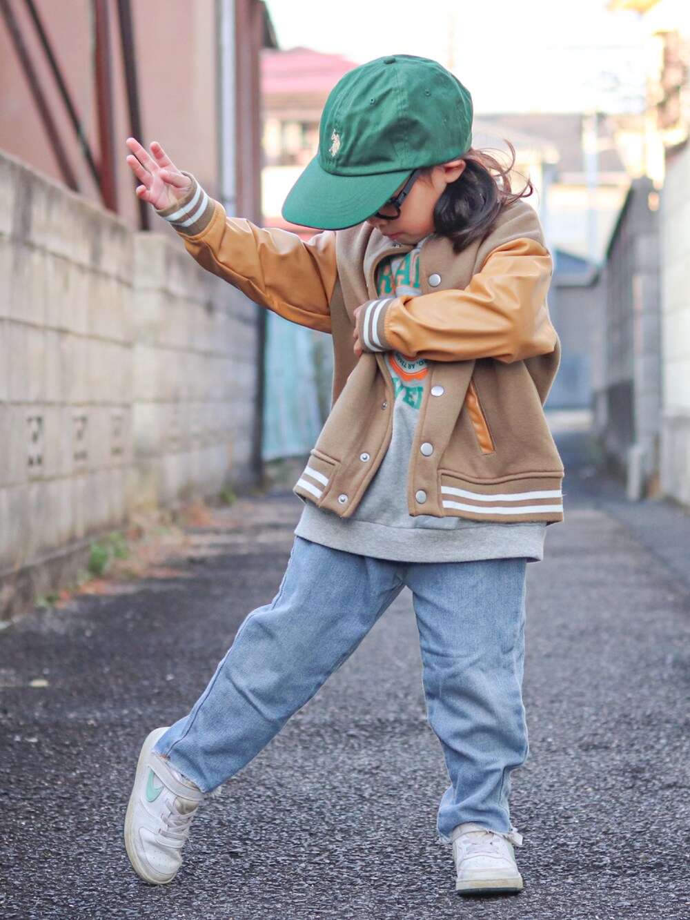 グレー系のスウェット、ベージュ系のスタジャン、ブルー系のデニムパンツを着用したキッズの冬コーディネートの4枚目の写真