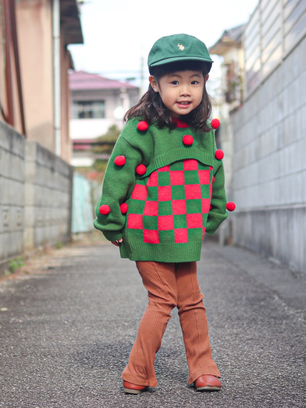 グリーン系のニット/セーター、ベージュ系のその他アウター、ブラウン系のパンツを着用したキッズの冬コーディネートの2枚目の写真