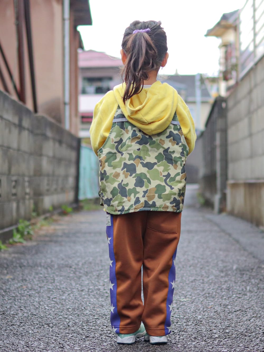 イエロー系のパーカー、その他のベスト、ブラウン系のその他パンツを着用したキッズの冬コーディネートの3枚目の写真