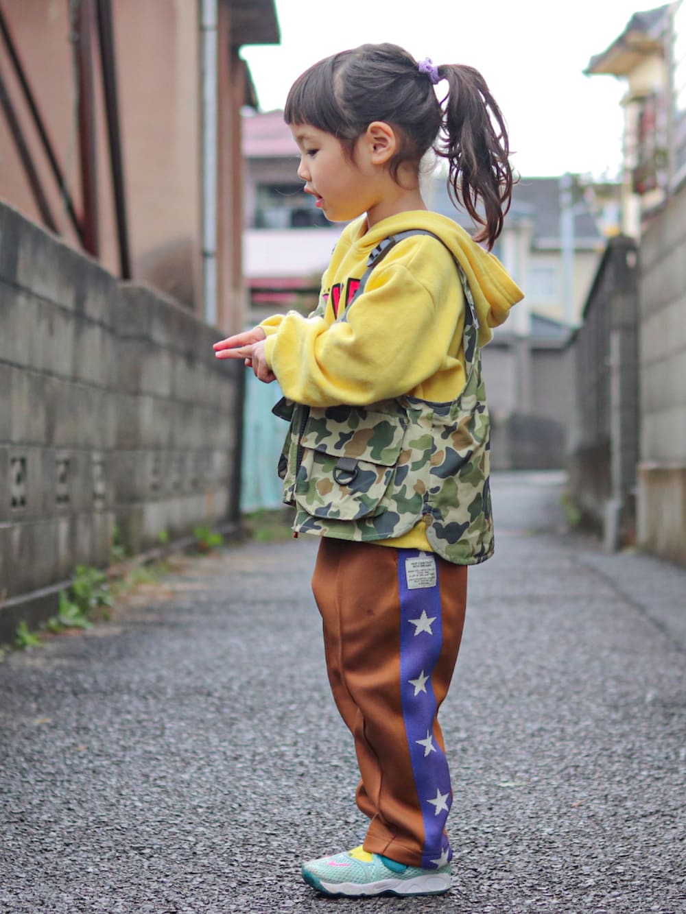 イエロー系のパーカー、その他のベスト、ブラウン系のその他パンツを着用したキッズの冬コーディネートの2枚目の写真