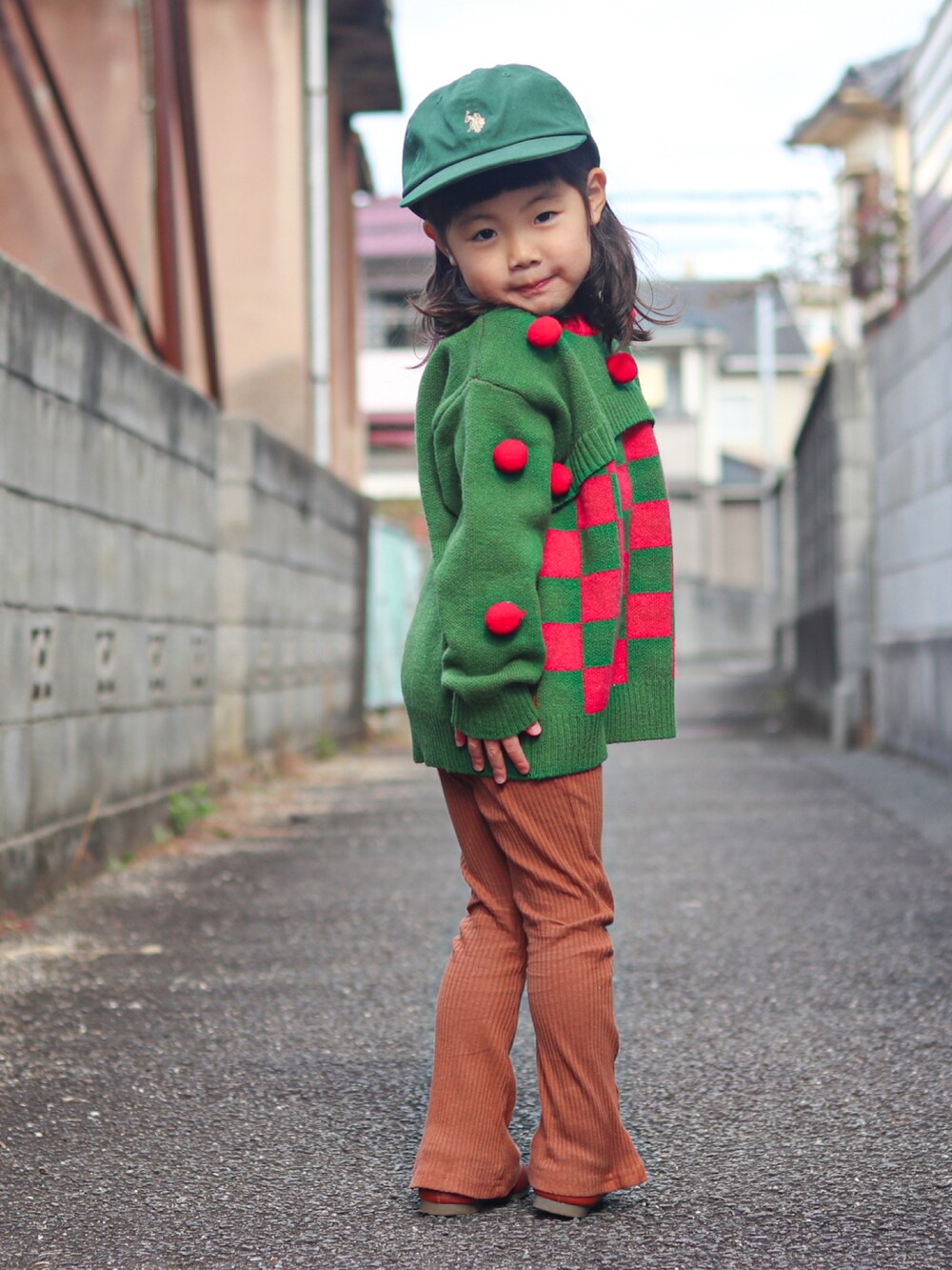 グリーン系のニット/セーター、ベージュ系のその他アウター、ブラウン系のパンツを着用したキッズの冬コーディネートの3枚目の写真