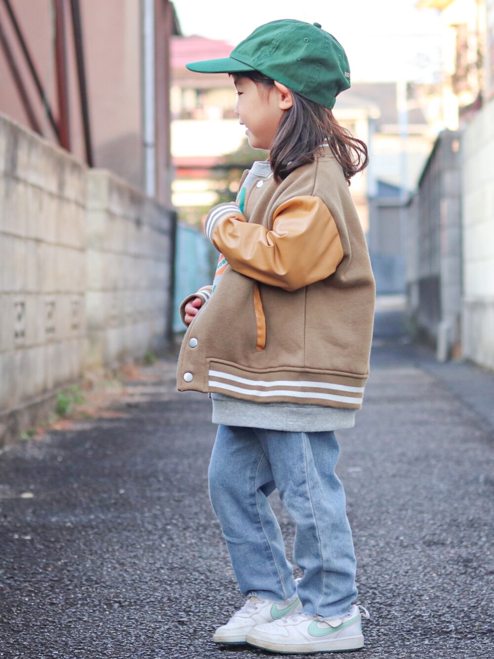 グレー系のスウェット、ベージュ系のスタジャン、ブルー系のデニムパンツを着用したキッズの冬コーディネートの2枚目の写真