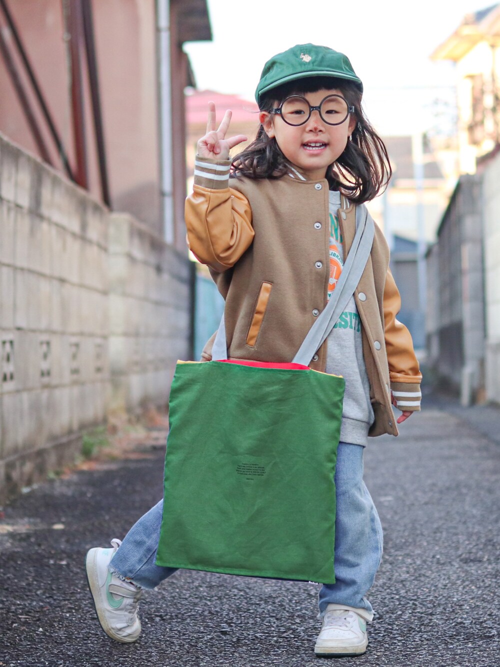 グレー系のスウェット、ベージュ系のスタジャン、ブルー系のデニムパンツを着用したキッズの冬コーディネートの5枚目の写真