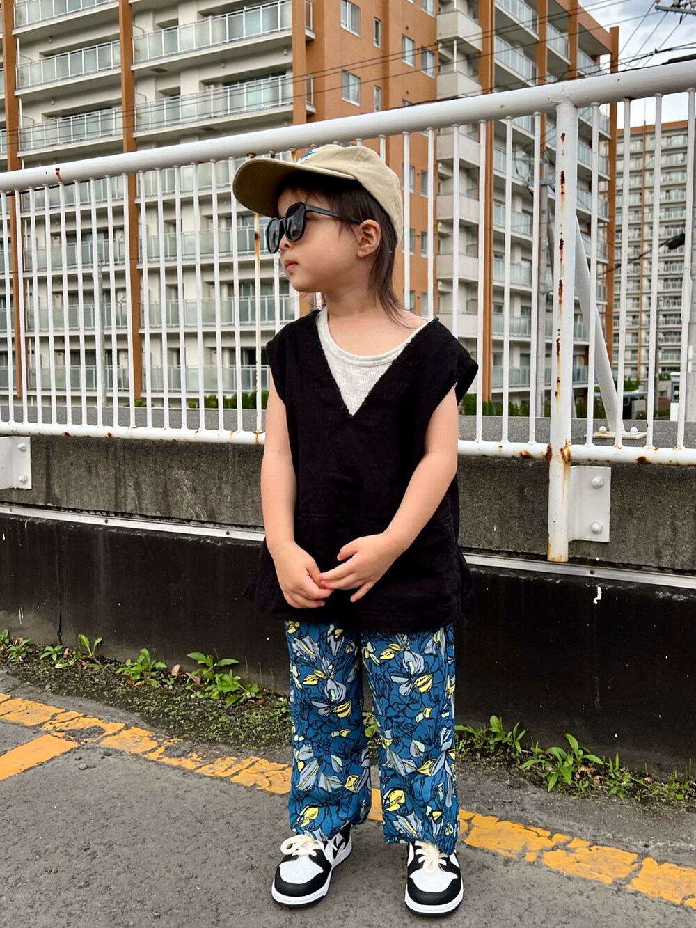 ブラック系のベスト、ブルー系のその他パンツ、ホワイト系のスニーカーを着用したキッズの秋コーディネートの2枚目の写真