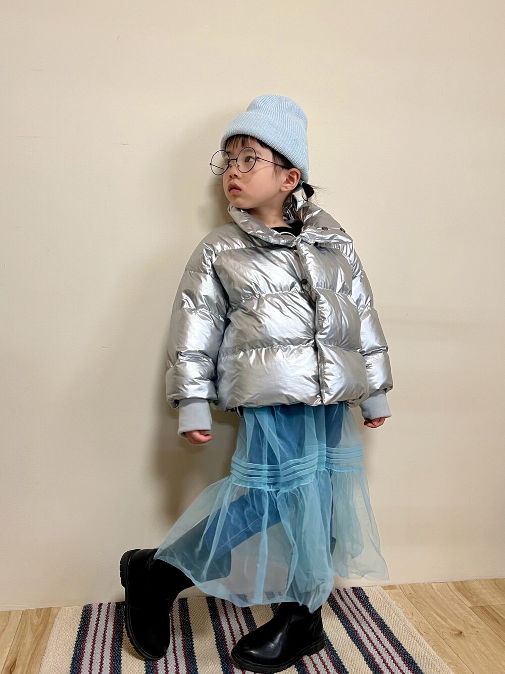 シルバー系のブルゾン、ブルー系のスカート、ブルー系のその他パンツを着用したキッズの冬コーディネートの2枚目の写真