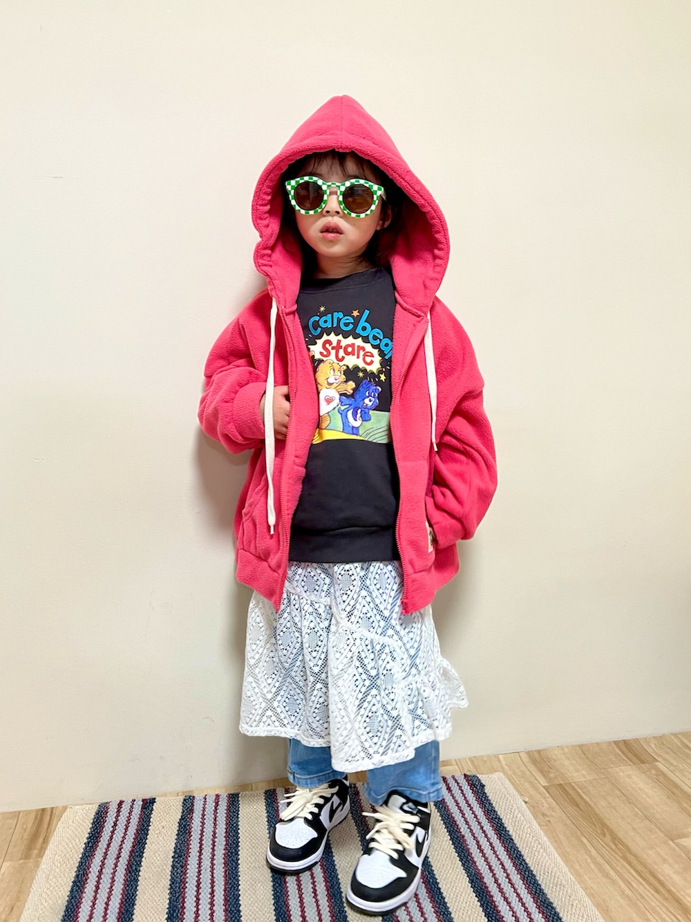 ホワイト系のワンピース、ブルー系のデニムパンツ、ホワイト系のスニーカーを着用したキッズの冬コーディネートの2枚目の写真