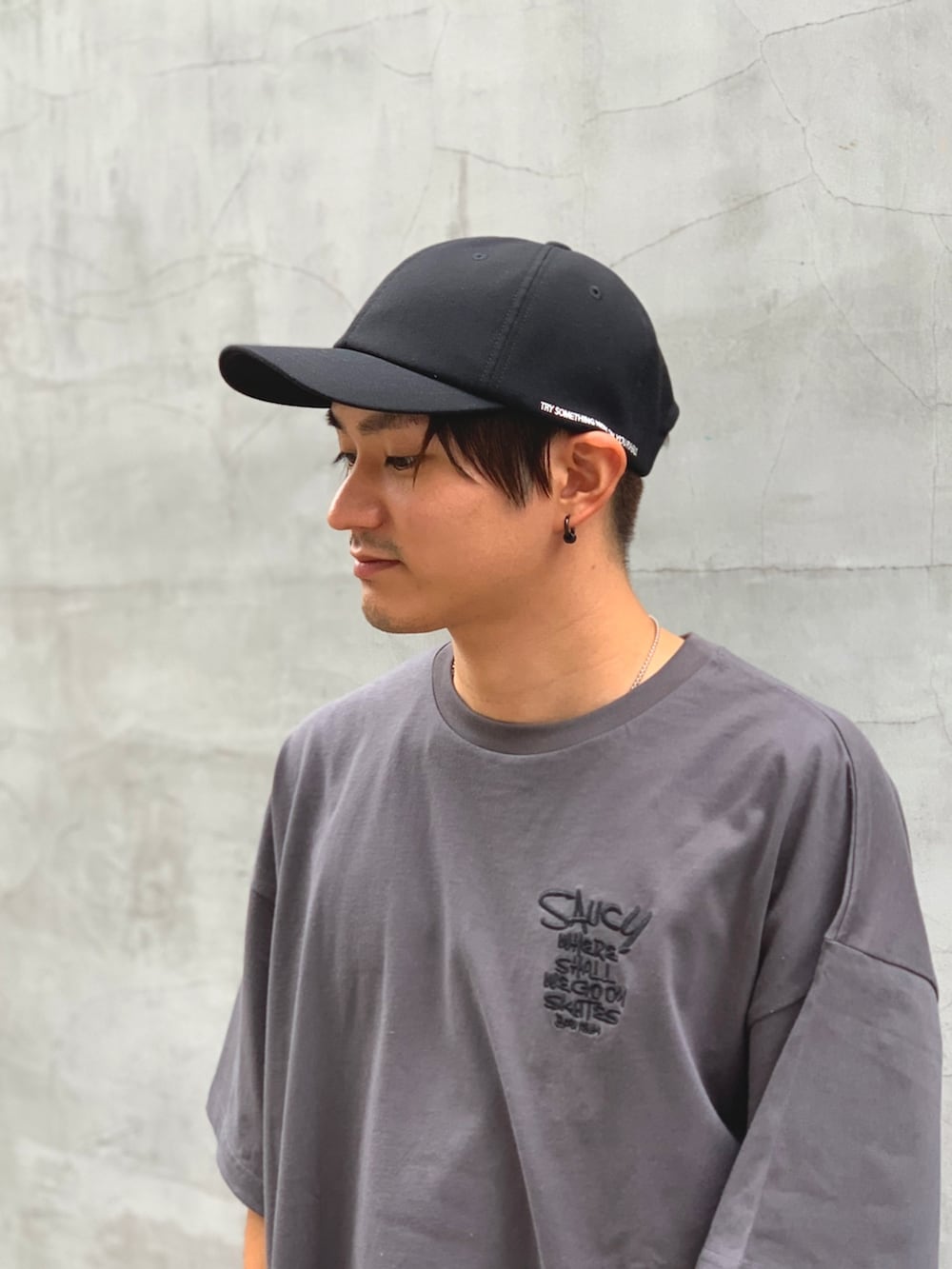 グレー系のTシャツ/カットソー、ブルー系のデニムパンツ、ブラック系のキャップを着用したメンズの夏コーディネートの2枚目の写真