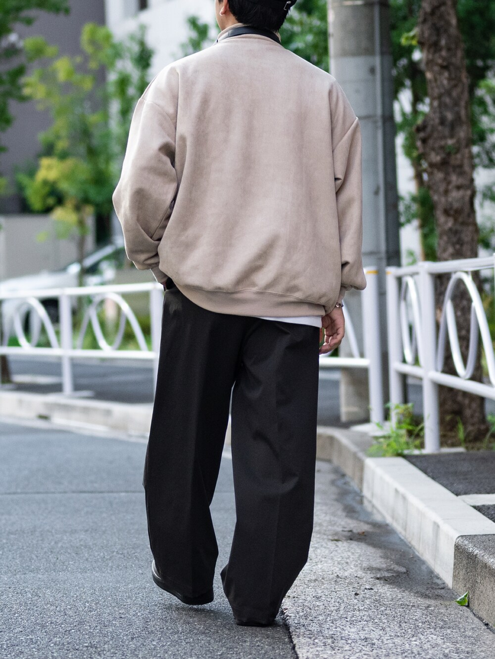 グレー系のスラックス、ブラック系のスニーカー、ベージュ系のスウェットを着用したメンズの秋コーディネートの4枚目の写真