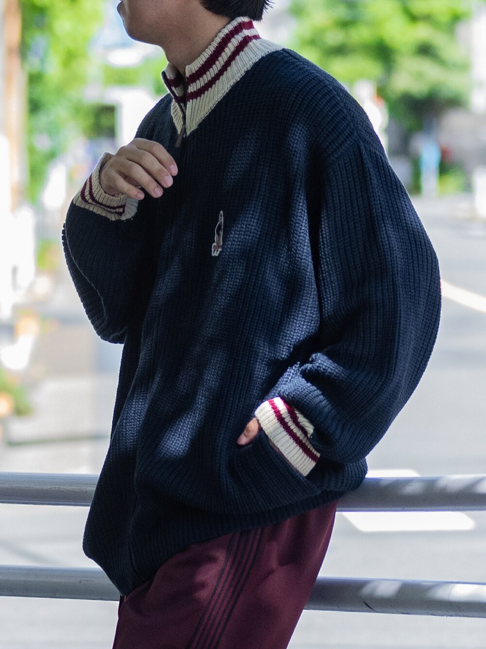 ブルー系のニット/セーター、グレー系のその他パンツ、ブラック系のスニーカーを着用したメンズの秋コーディネートの2枚目の写真