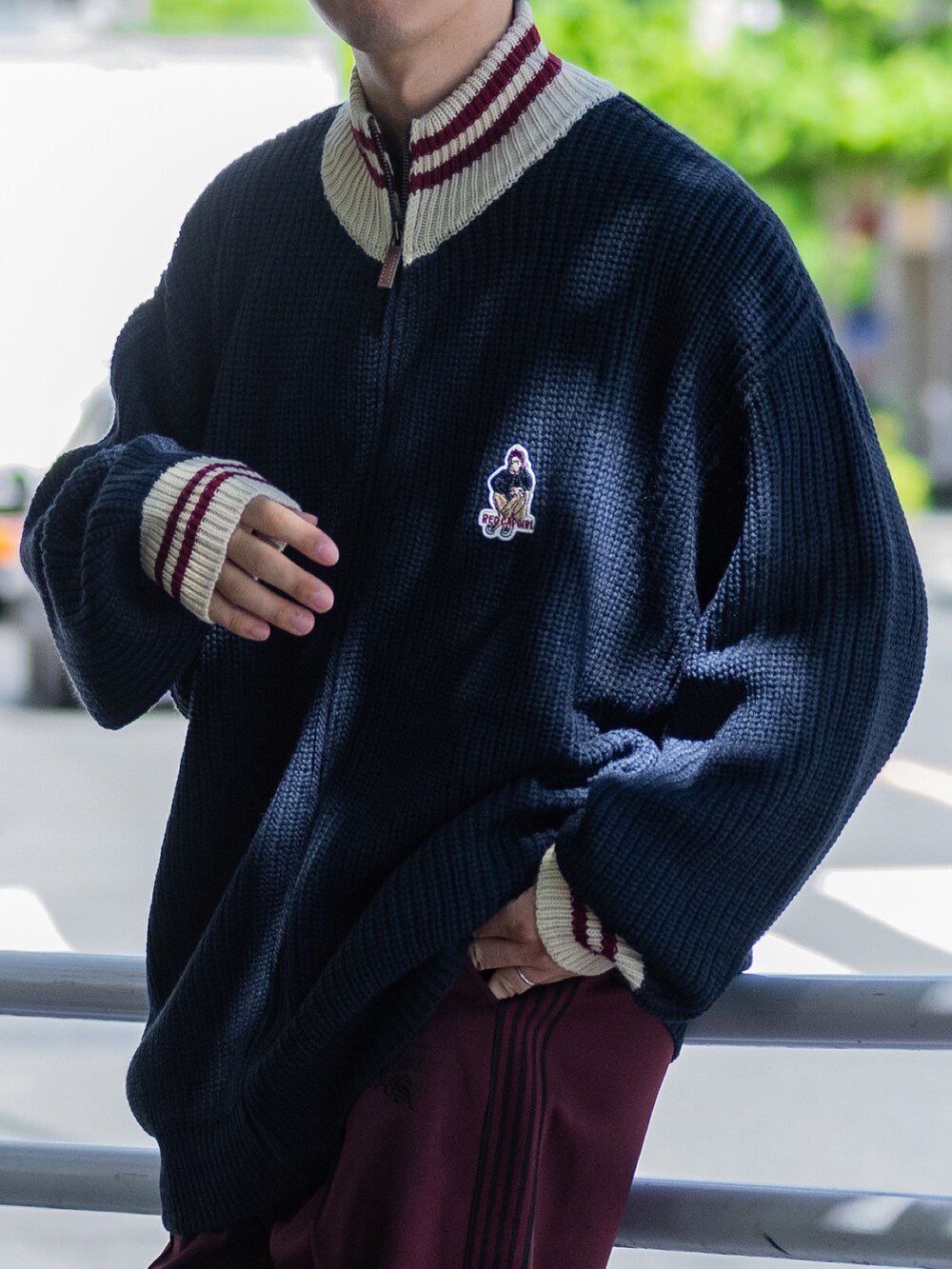 ブルー系のニット/セーター、グレー系のその他パンツ、ブラック系のスニーカーを着用したメンズの秋コーディネートの5枚目の写真