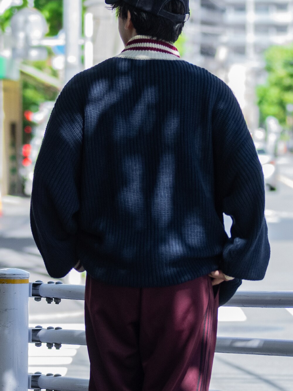 ブルー系のニット/セーター、グレー系のその他パンツ、ブラック系のスニーカーを着用したメンズの秋コーディネートの3枚目の写真